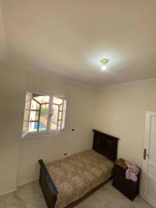 a bedroom with a bed and a window at ڤيلا في الساحل الشمالي in Borg El Arab