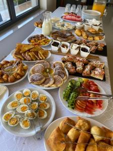 a table with many plates of food on it at Hotel Selfo in Gjirokastër