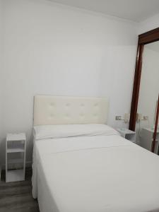 a bedroom with a white bed and a window at CHOCOLATE y MENTA REDONDELA in Redondela