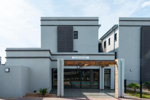 a white building with a sign that reads potus at MM Stays G206 at Habitat Kappa - Sarona City in Gaborone