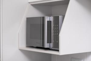 a microwave oven on a shelf in a kitchen at MM Stays G206 at Habitat Kappa - Sarona City in Gaborone