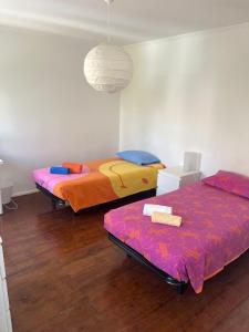 two beds sitting in a room with wood floors at Duplex no estoril in Estoril