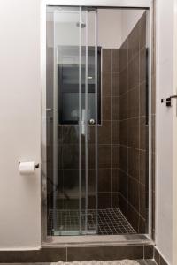 a shower with a glass door in a bathroom at MM Stays G206 at Habitat Kappa - Sarona City in Gaborone