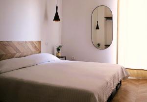 a bedroom with a white bed and a mirror at B&B Casa Valentina in Rome
