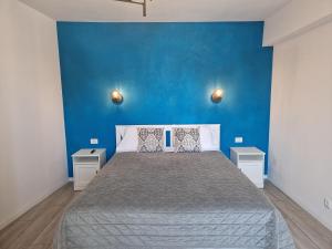 a bedroom with a bed with a blue wall at Central Mangalia in Mangalia