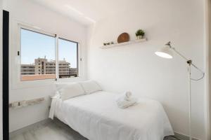 een witte slaapkamer met een bed en een raam bij Ático 3 Palmeras Albatros in San Miguel de Abona +23 foto's