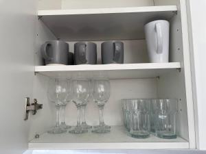 een rij wijnglazen op een plank bij Kingsbury Service Accommodation in Colindale +49 foto's