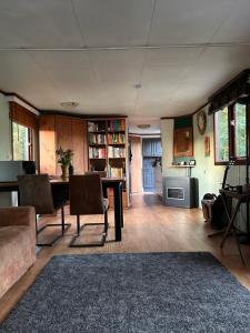 a living room with a table and chairs and a kitchen at Welcome, relax and enjoy your stay in Putten