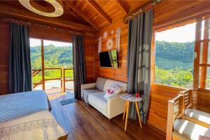 a bedroom with a bed and a large window at Pousada Hoff Haus in Pomerode