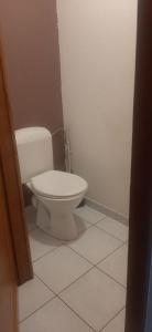 Un baño con un inodoro blanco en una habitación. en A private room in a flat shared familly home, en Mulhouse