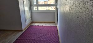 Una habitación con una alfombra morada frente a una ventana. en A private room in a flat shared familly home, en Mulhouse