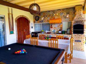 a kitchen with a pool table in a room at Recantos Pinheiros - Casa inteira, até 15 hóspedes - Piscina privativa, sinuca, ar condicionado e TVs nos 4 quartos - Condomínio Orla 500, lado praia - Unamar, Cabo Frio-RJ in Tamoios