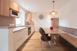 a kitchen with a wooden table and a dining room at Francesca's home in Pozza di Fassa