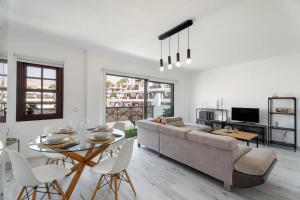 een woonkamer met een bank, een tafel en stoelen bij Ático 3 Palmeras Albatros in San Miguel de Abona