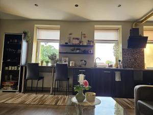 a kitchen with a bar with chairs and a table at Oasis in Ventspils