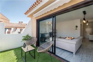 een woonkamer met een bank en stoelen op een balkon bij Ático 3 Palmeras Albatros in San Miguel de Abona