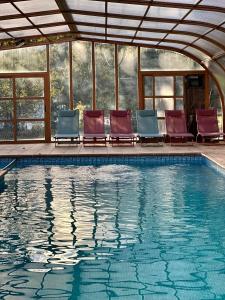 a group of chairs sitting next to a swimming pool at Poble Rural Puig Arnau - Pubilló in Oden