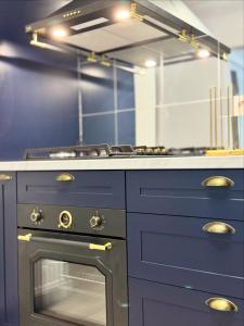 a kitchen with a stove and a blue counter top at Boutique Apartment in Ploieşti