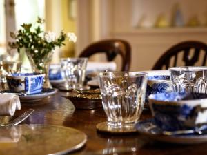 un tavolo di legno con bicchieri e piatti di Barnard House a Great Yarmouth