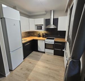 a kitchen with white cabinets and a white refrigerator at Studio Ski Lodge in Rovaniemi +4 photos