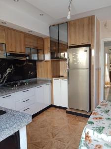 a kitchen with white cabinets and a stainless steel refrigerator at vacation house 120 dt par nuitée kélibia in Kelibia