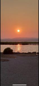 a sunset over a body of water with the sun setting at À mi-chemin in Claira