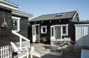 a house with a deck with a table and chairs at Cozy summer cottage in Hasmark in Otterup