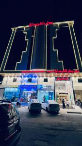 two cars parked in front of a gas station at night at شقق دار الفرسان المخدومة in Quai