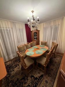 einen Esstisch mit Stühlen und einem Kronleuchter in der Unterkunft Vila CETINA in Fundu Moldovei