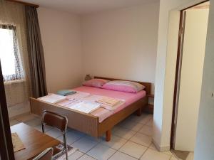 a small room with a bed with a table and a chair at Casa Gudelj in Pirovac