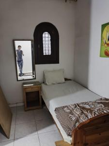 a small bedroom with a bed and a mirror at chalet for rent at marina 7 el alamein 4 bedrooms air conditions marina card in El Alamein