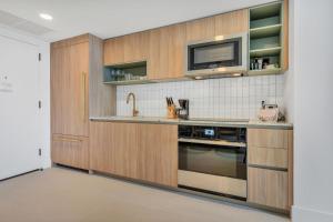 cocina con armarios de madera y TV en la pared en Luxury experience - views of MIAMI city center, en Miami