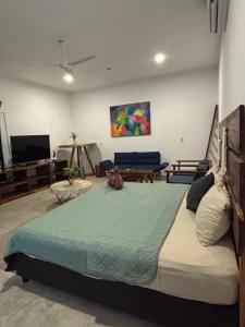 a bedroom with a large bed and a living room at Hidden Port TTipis Vista Carrizalillo in Puerto Escondido
