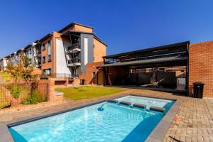 a large swimming pool in front of a building at AlimamaSpaces Bonitos Waterfall Ridge in Midrand