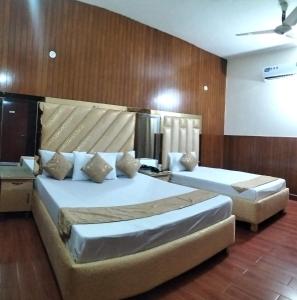two beds in a room with wooden walls at Hotel 4 Season Lahore in Lahore