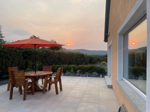 a table and chairs with an umbrella on a patio at Mon Petit Cottage - B&B and Guest House in Bunclody in Bunclody
