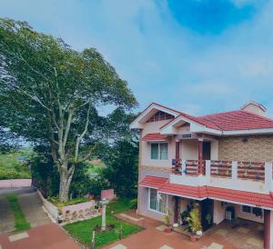a house with a tree in front of it at Willostays Cloudhill ooty in Ooty