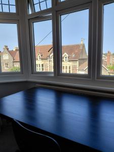 ブリストルにあるQuiet Terraced Houseの3つの窓とその前にテーブルがある部屋