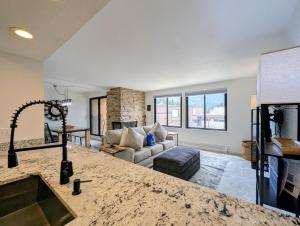 a kitchen and living room with a couch and a fireplace at Edgewater 1451 by SummitCove Lodging in Keystone