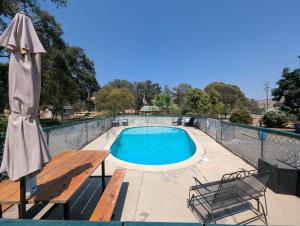 a swimming pool with a bench and an umbrella at Squaw Valley Motel Room #1 in Squaw Valley