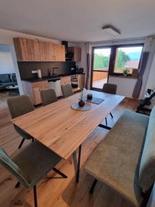 Un comedor con mesa y sillas de madera. en Landhaus Poppler mit Aufzug, en Hopferau