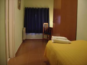 a room with a bed and a chair and a window at Albergue Quinta del Jalón in Granja de San Pedro