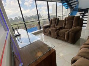 a living room with two chairs and a glass table at Edificio Confort in San Felipe Hueyotlipan