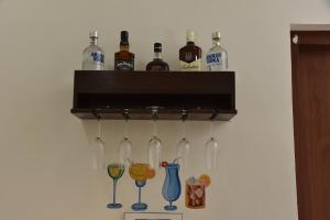 a rack with wine bottles and glasses on a wall at The Verandah in Jodhpur