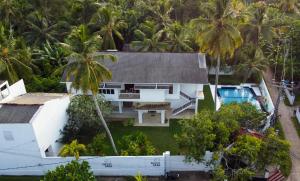 an aerial view of a house with a swimming pool and palm trees at Ricco Tara Villa in Boossa