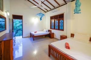 a room with two beds and a bench in it at Ricco Tara Villa in Boossa