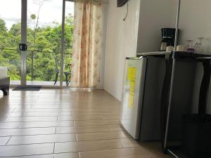 a kitchen with a refrigerator and a large window at Villas Josipek in Fortuna