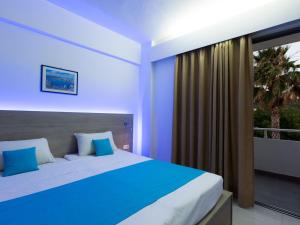 a bedroom with a large bed and a balcony at Vergina Sun in Faliraki +12 photos