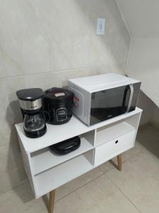 a microwave sitting on top of a white cabinet at Recanto da Totô in Paraty
