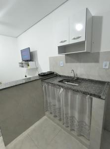 a kitchen counter with a sink and a laptop on it at Recanto da Totô in Paraty
